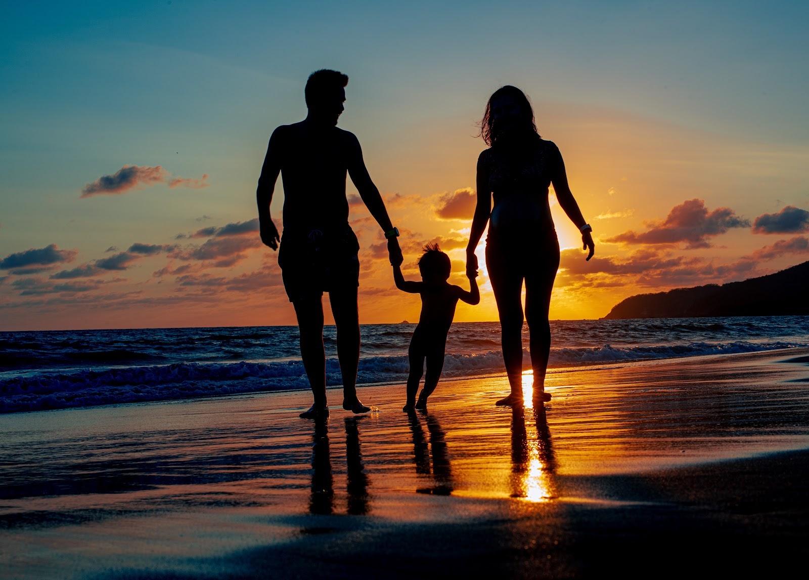 A family walking along the beach at sunset in Zihuatanejo