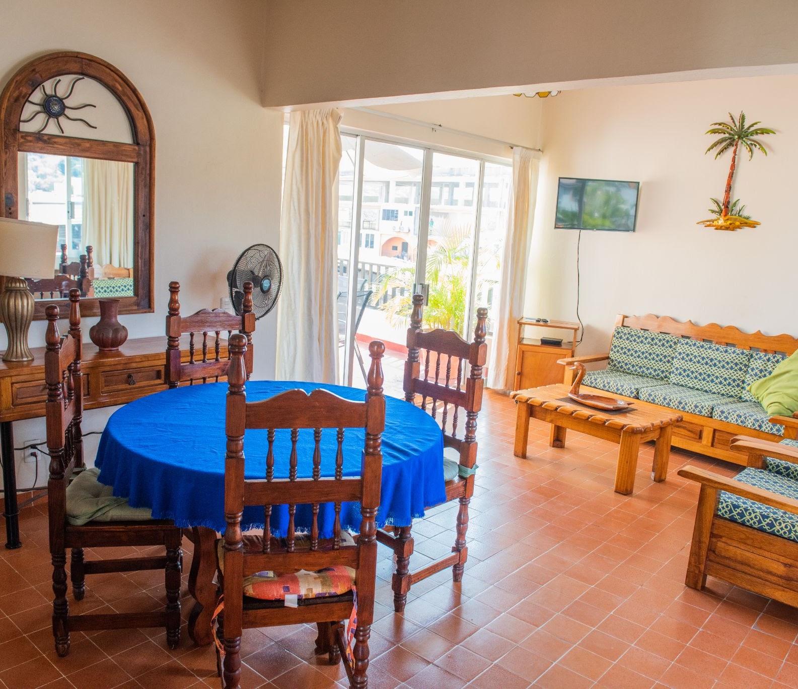 Living and dining room of a two-bedroom apartment at Hotel Valle, with the balcony open to the street